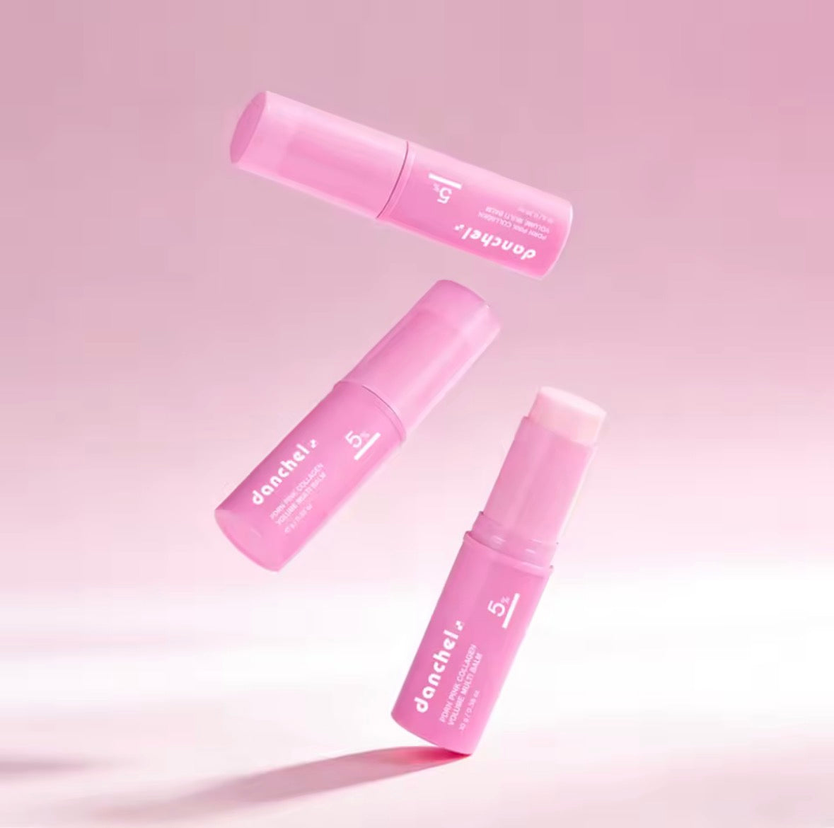 Three Danchel PDRN Pink Collagen Balm Sticks floating against a soft pink background, showcasing the lightweight stick format